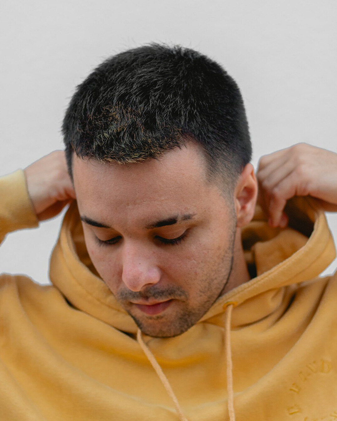 Studio portrait of a Brazilian man with dark skin and a shaved head