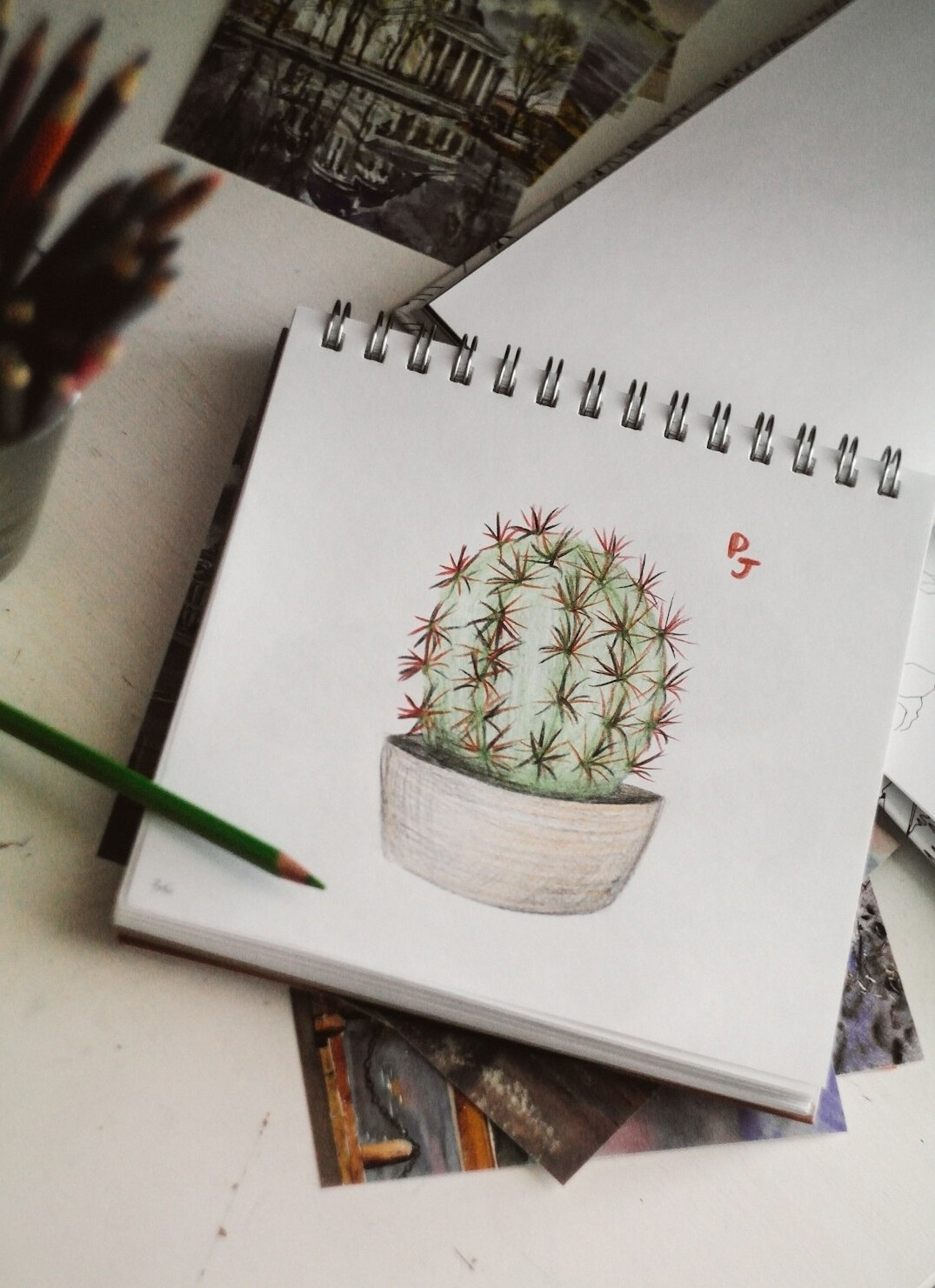 Desk with an open notebook, pen and a small plant in soft morning light